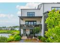 Rear balcony overlooks the community pond, complemented by lush landscaping and hardscape at 6895 Whitman Walk, Alpharetta, GA 30005
