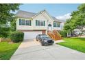 Well-kept front yard features a home with green shutters, a manicured lawn, and a two-car garage at 1147 Saint Phillips Ct, Locust Grove, GA 30248