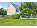 Grassy side yard with mature trees, and a partial view of the home's exterior at 1147 Saint Phillips Ct, Locust Grove, GA 30248