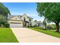 Elegant home boasts an expansive driveway, mature trees, manicured lawn and black trim at 3684 Clearbrooke Way, Duluth, GA 30097