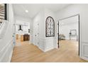 Bright hallway with wood floors, staircase, decorative molding, and views into the kitchen and living spaces at 3684 Clearbrooke Way, Duluth, GA 30097