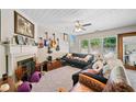 Cozy living room featuring a fireplace, ceiling fan and a set of large windows at 4161 Magnolia Glen Walk, Norcross, GA 30093