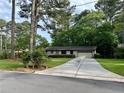 Inviting single-story home with lush lawn, driveway and a beautiful landscape, surrounded by mature trees at 4323 Darwen Ct, Tucker, GA 30084