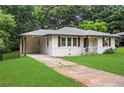 Attractive home featuring white siding, wood shutters, and a convenient covered parking area at 629 Dunton Se Cir, Smyrna, GA 30082