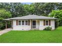 Charming single-story home featuring white siding, a well-manicured lawn, and a covered carport on a tree-lined street at 629 Dunton Se Cir, Smyrna, GA 30082