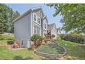 View of home featuring landscaped yard, small patio, basement entrance, and mature trees at 750 Gates Ln, Alpharetta, GA 30022
