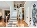 Bright foyer featuring hardwood floors, staircase with wood and wrought iron, and neutral walls at 750 Gates Ln, Alpharetta, GA 30022