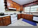 Traditional kitchen features wooden cabinets, white appliances, and marble-like tile flooring at 2480 Sewell Mill Rd, Marietta, GA 30062
