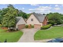 Expansive aerial view of a traditional home with a lush green lawn, mature trees, and a circular driveway at 435 Ruby Forest Pkwy, Suwanee, GA 30024