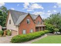 Aerial view of a brick home with a well-manicured lawn, detached garage, and mature landscaping at 435 Ruby Forest Pkwy, Suwanee, GA 30024