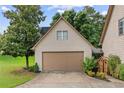 Detached garage featuring siding, large door, and mature landscaping that offers privacy and visual appeal at 435 Ruby Forest Pkwy, Suwanee, GA 30024