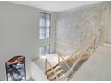 Unfinished staircase with temporary railings beneath a two-story window and light stone wall at 120 Wood River Ct, Johns Creek, GA 30097