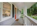 Inviting front porch featuring a red front door and view of landscaped yard at 2383 Edgewater Sw Dr, Atlanta, GA 30311