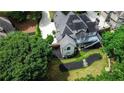 Aerial view of a home's backyard featuring a deck, patio, and mature trees at 9360 Nesbit Lakes Dr, Alpharetta, GA 30022