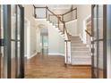 Inviting foyer features hardwood floors, staircase with white railings, and plenty of natural light at 9360 Nesbit Lakes Dr, Alpharetta, GA 30022