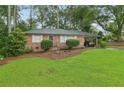 Charming brick home featuring a well-manicured lawn and lush landscaping, complete with an attached carport at 1849 Clay Sw Rd, Mableton, GA 30126