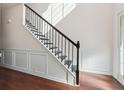 Bright interior featuring a staircase with black iron railings and decorative wall paneling at 7434 Absinth Dr, Atlanta, GA 30349