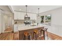 Bright kitchen with an island, pendant lighting, stainless steel appliances and warm wood floors at 3422 Maplehurst Dr, Decatur, GA 30032