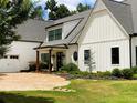 Charming white farmhouse exterior with a circular driveway and black trimmed windows at 3842 Ernest W Barrett Sw Pkwy, Marietta, GA 30064
