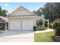 Two-car garage and front exterior featuring a well-manicured lawn, flower beds, and a curved sidewalk at 428 Redwood Trl, Canton, GA 30114