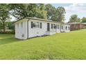 Angle shot of home showcasing white brick exterior, green lawn, and mature landscaping at 1261 Cliffwood Se Dr, Smyrna, GA 30080