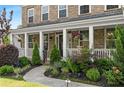 Inviting front porch with lush landscaping and charming architectural details at 129 Millstone Way, Canton, GA 30115