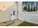 Close-up of the home's side entrance with a white door, decorative trim, and a fenced-in yard at 2657 Albion Farm Way, Duluth, GA 30097