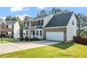 Traditional two-story home with brick and siding, a well-manicured lawn, and a driveway at 3943 Alexandra Oak Ct, Suwanee, GA 30024