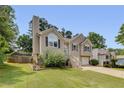 Well-manicured lawn leading up to a two story home with a visible chimney and 2-car garage at 503 Silver Maple Ln, Woodstock, GA 30189