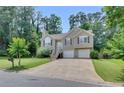 Traditional home with a two car garage, lush green lawn and mature trees in a suburban setting at 503 Silver Maple Ln, Woodstock, GA 30189