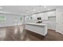Bright, open-concept kitchen featuring an island with quartz countertops and modern pendant lighting at 6104 Marigold Way, Atlanta, GA 30349