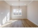 Bright dining room featuring wood floors, a modern chandelier, and ample natural light at 1996 Deco Dr, Kennesaw, GA 30144