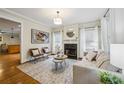Cozy living room featuring a fireplace, neutral furnishings, and an open doorway to the kitchen at 261 Elmira Ne Pl, Atlanta, GA 30307