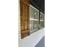 Detailed view of a window adorned with stylish wood shutters, complemented by white trim and a brick exterior at 2786 Knollview Dr, Decatur, GA 30034