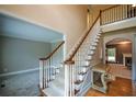 Traditional staircase with carpeted steps, wood railing, and white spindles leading to the upper level at 1703 Rifle Sw Rdg, Marietta, GA 30064