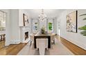 Bright dining room featuring a fireplace, chandelier, hardwood floors, and modern art at 235 The Prado N, Atlanta, GA 30309