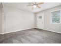 Bright living room with neutral paint, ceiling fan, and a door leading outside at 211 Margaret St, Fairburn, GA 30213