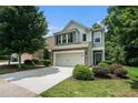 Charming two-story home with a stone facade, manicured lawn, and a two-car garage with green shrubs at 85 Brushed Ives Ct, Lawrenceville, GA 30045