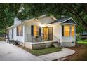 Cozy home featuring a bright yellow front door, bay windows, and covered front porch seating area at 901 Winfield Se Ave, Atlanta, GA 30316
