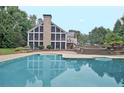Relaxing backyard with a swimming pool, stone patio, screened porch, and lush landscaping at 104 Hidden Springs Ln, Peachtree City, GA 30269