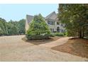 Elegant home showcasing a circular driveway with professional landscaping and mature trees at 104 Hidden Springs Ln, Peachtree City, GA 30269