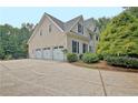 Spacious three-car garage with a long driveway and mature landscaping at 104 Hidden Springs Ln, Peachtree City, GA 30269