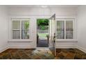 Bright entryway with decorative tile flooring, large windows with shutters, and an open door to the backyard at 2855 Middlecreek Way # 2855, Cumming, GA 30041
