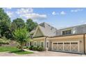 Home features a multi-car garage, stone accents, and manicured landscaping at 2855 Middlecreek Way # 2855, Cumming, GA 30041