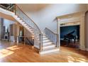 Spacious foyer featuring a staircase with iron railings and abundant sunlight at 652 Pathview Ct, Dacula, GA 30019