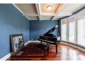 Music room with a grand piano, coffered ceilings, and natural light from large windows at 652 Pathview Ct, Dacula, GA 30019