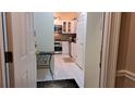 View from the hallway into the kitchen featuring white cabinets, tile floors and backsplash, and stainless steel appliances at 3275 Lenox Ne Rd # 110, Atlanta, GA 30324