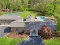 Aerial view showcasing the home's tennis court, swimming pool, and lush green surroundings at 860 Crest Valley Dr, Sandy Springs, GA 30327