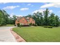 Brick home with green grass and mature trees at 125 Ancient Oak Ln, Stockbridge, GA 30281