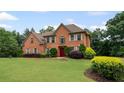 Attractive brick home featuring a manicured lawn, tasteful shrubbery and a bright red front door at 125 Ancient Oak Ln, Stockbridge, GA 30281